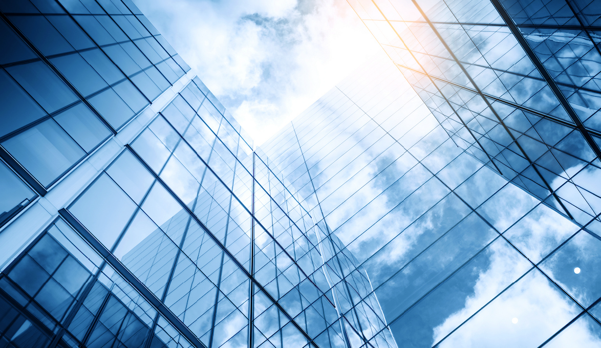 Several buildings reflecting the sky