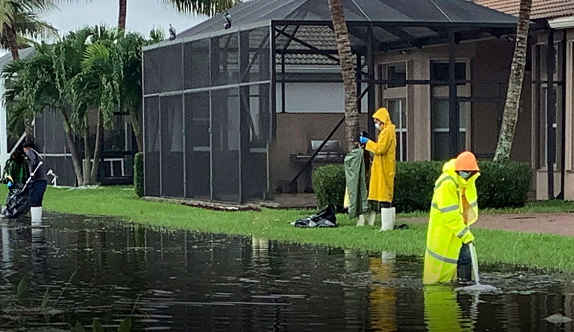 Workers sift through storm water after a hurricane has passed
