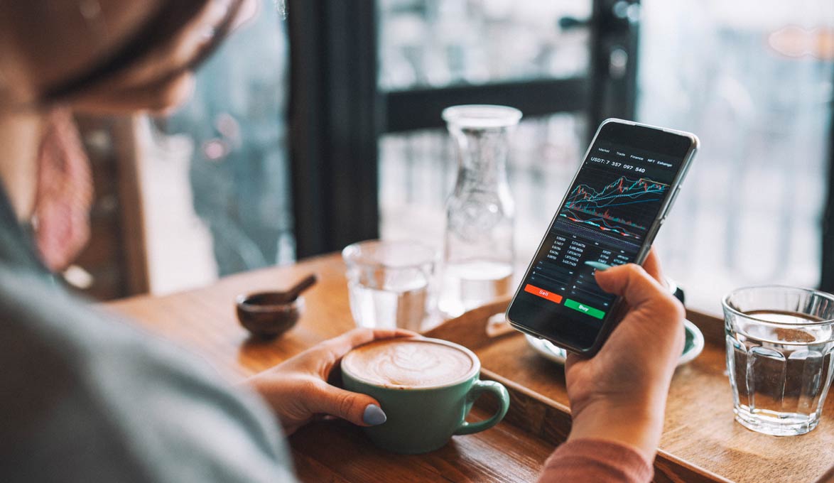 Woman looking at current stocks in coffee shop