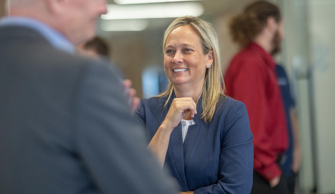 Jennifer Idell Speaking with Co-workers at Event