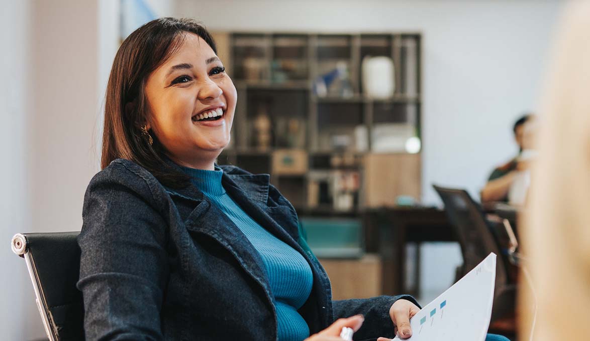 A smiling woman sitting in a chair