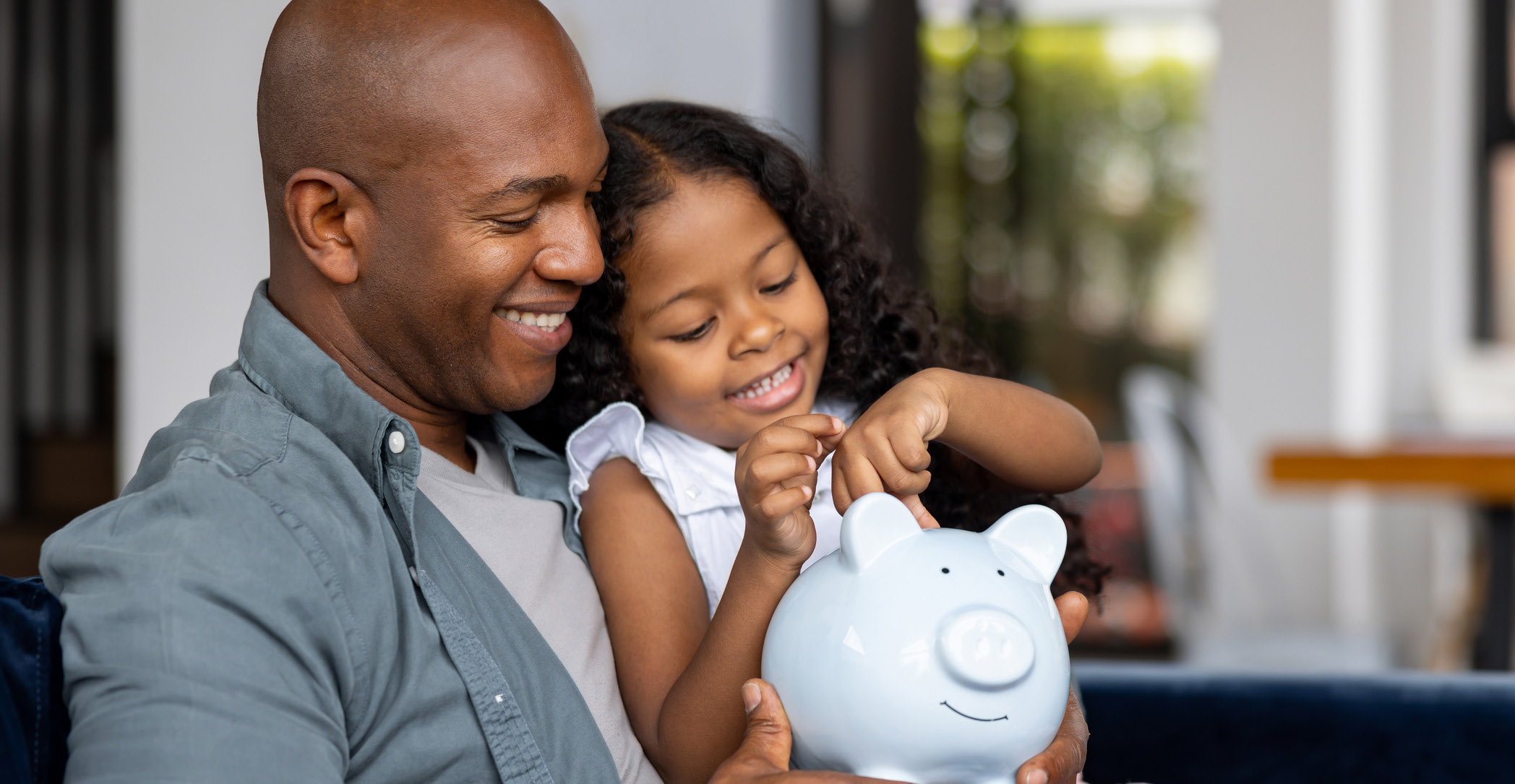 Father and Daughter Going Through Piggy Bank Together