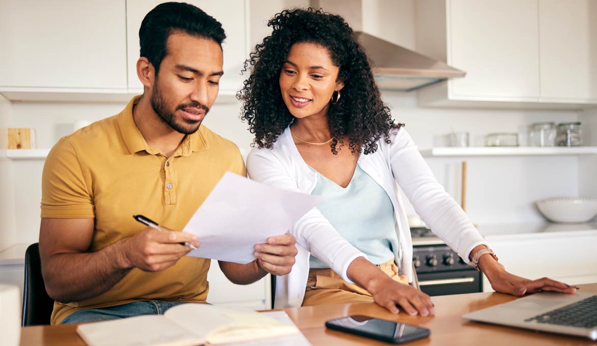 Couple reviewing finances together at kitchen counter