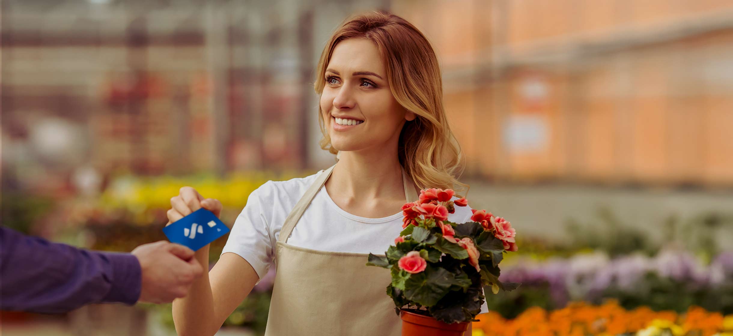 a woman make a SouthState debit card purchase in garden center