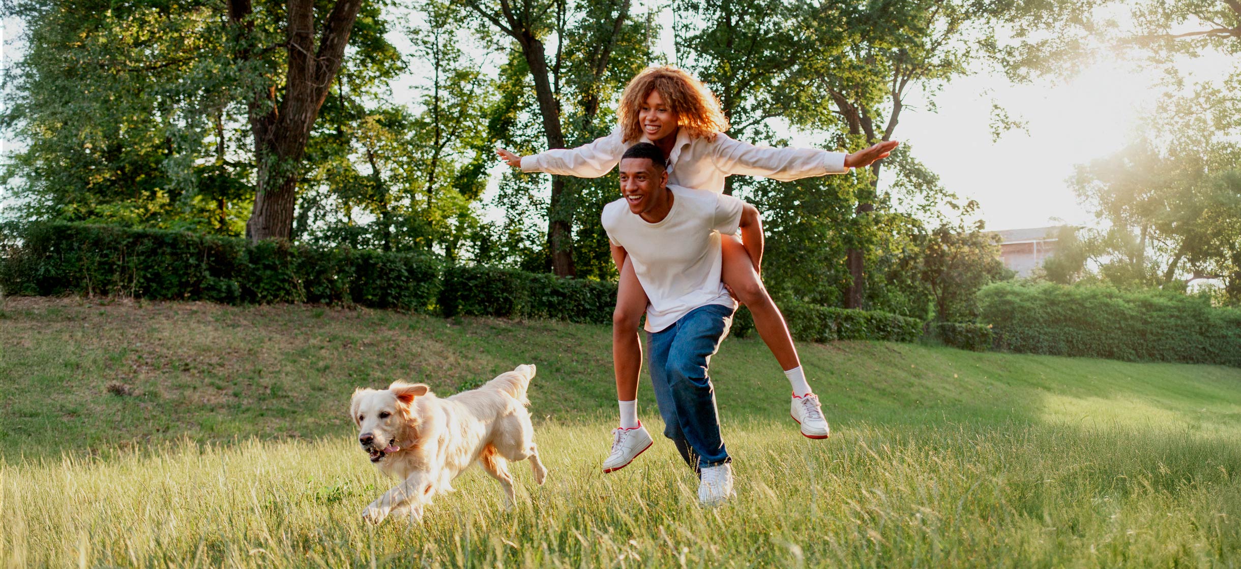 Young couple playing in field with dog