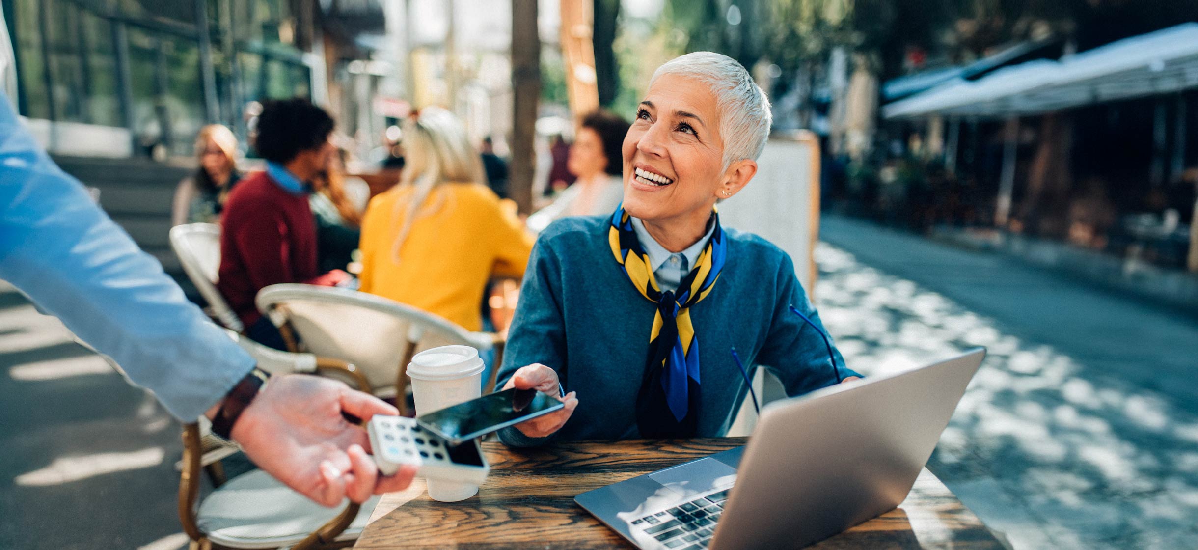 Woman at coffee shop paying on her phone using digital wallet