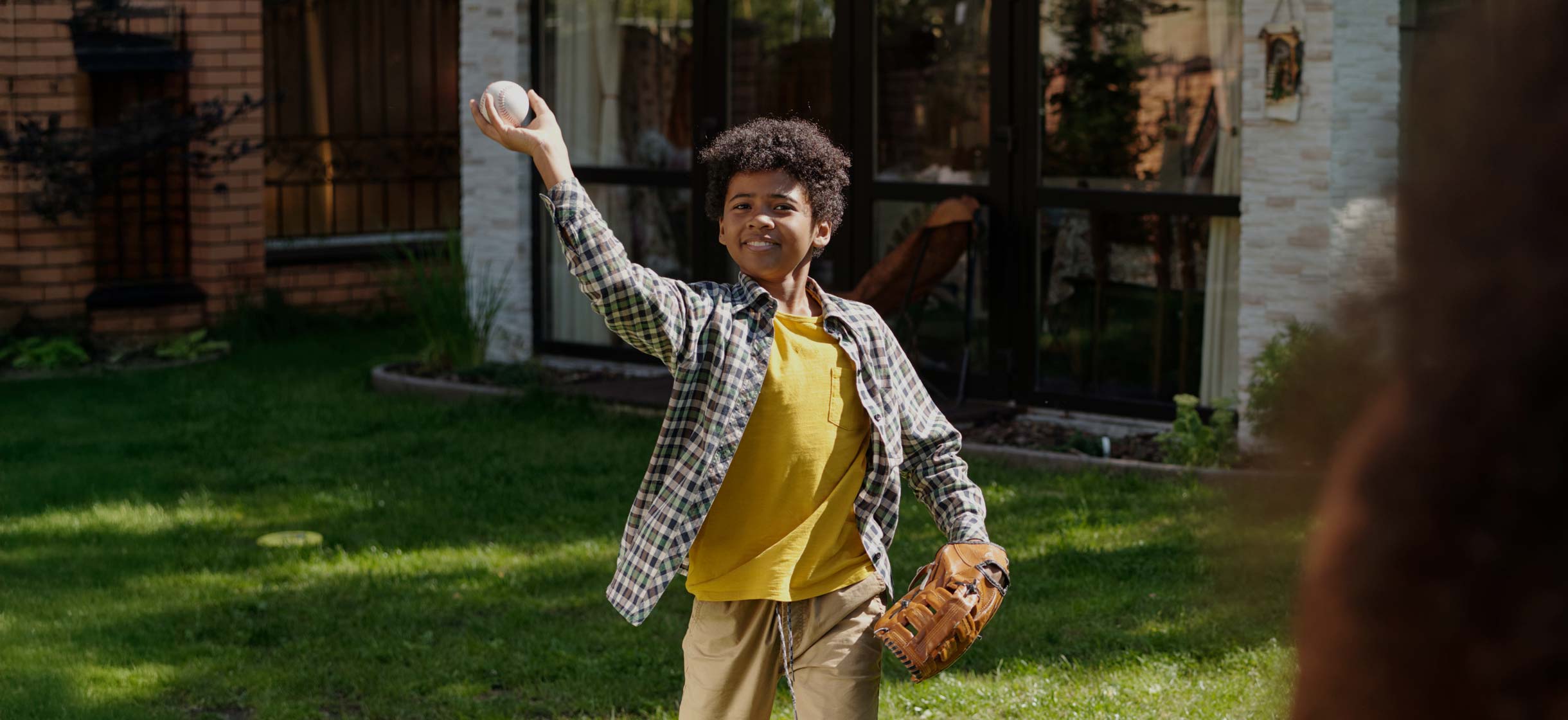 A man and his son play baseball in their yard