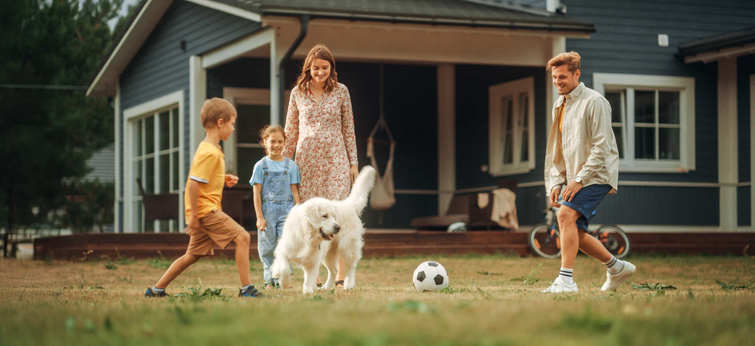 A family plays soccer in their yard