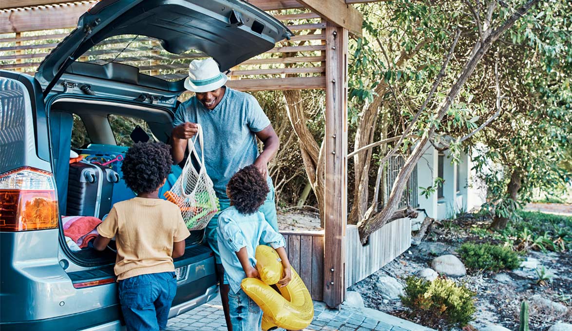 Family unloading toys from SUV.