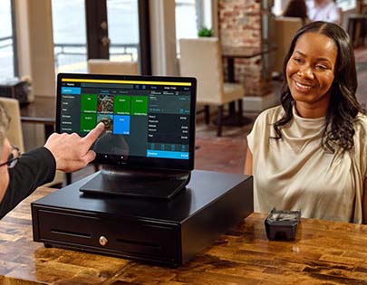 small business owner using pos terminal to accept mobile credit card payment