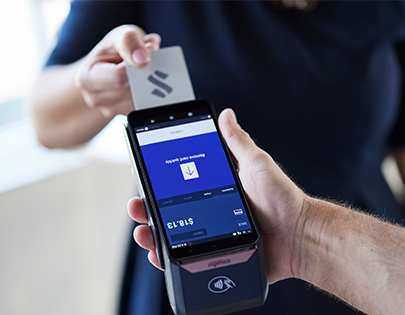 small business owner using pos terminal to accept mobile credit card payment