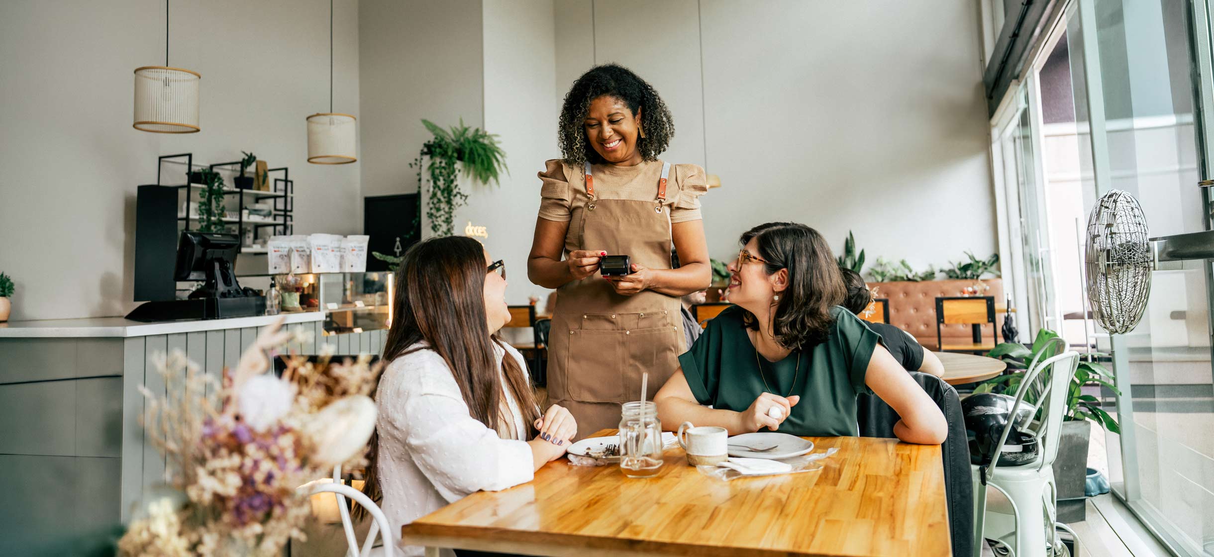 Small Business owner attending to customers in her cafe