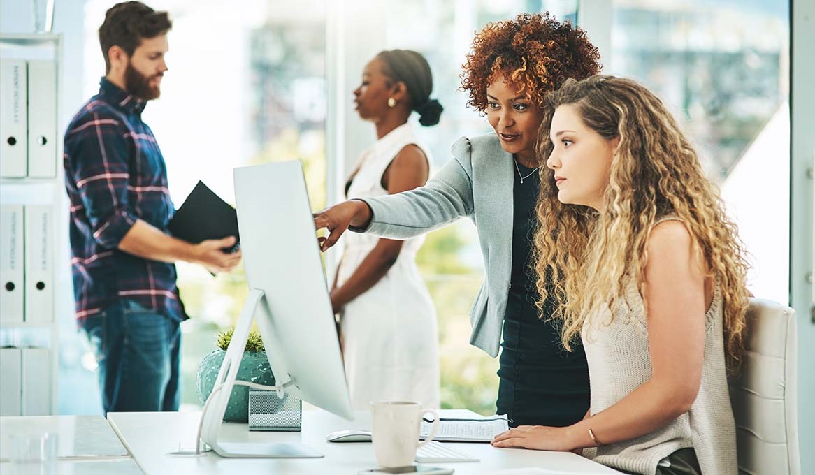 small business owner teaching employee how to use accounting software