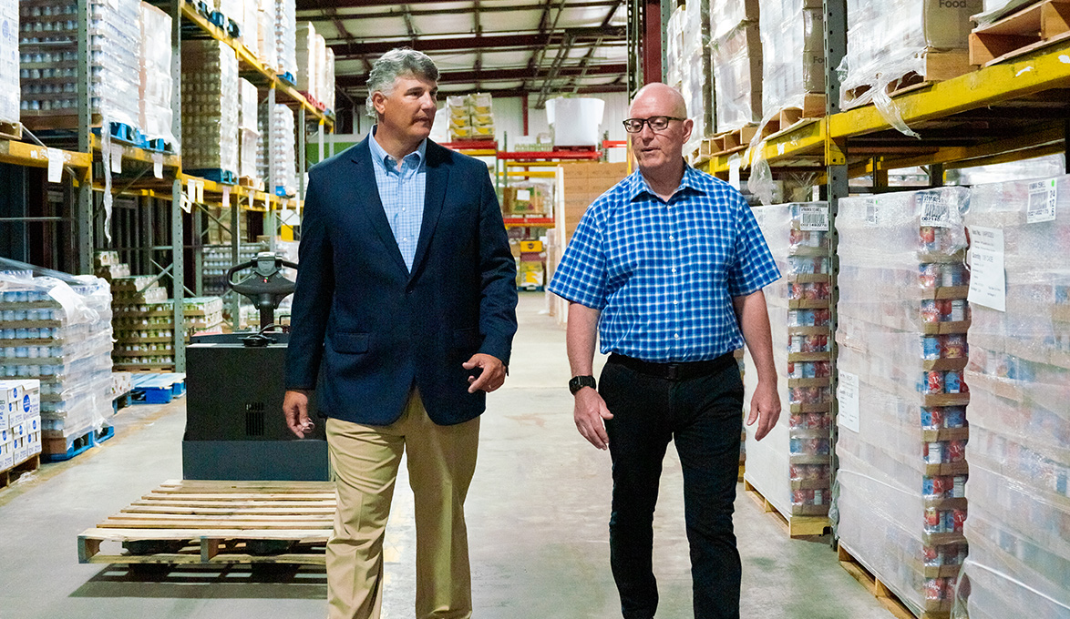 Two people walking through Low Country Food Bank.
