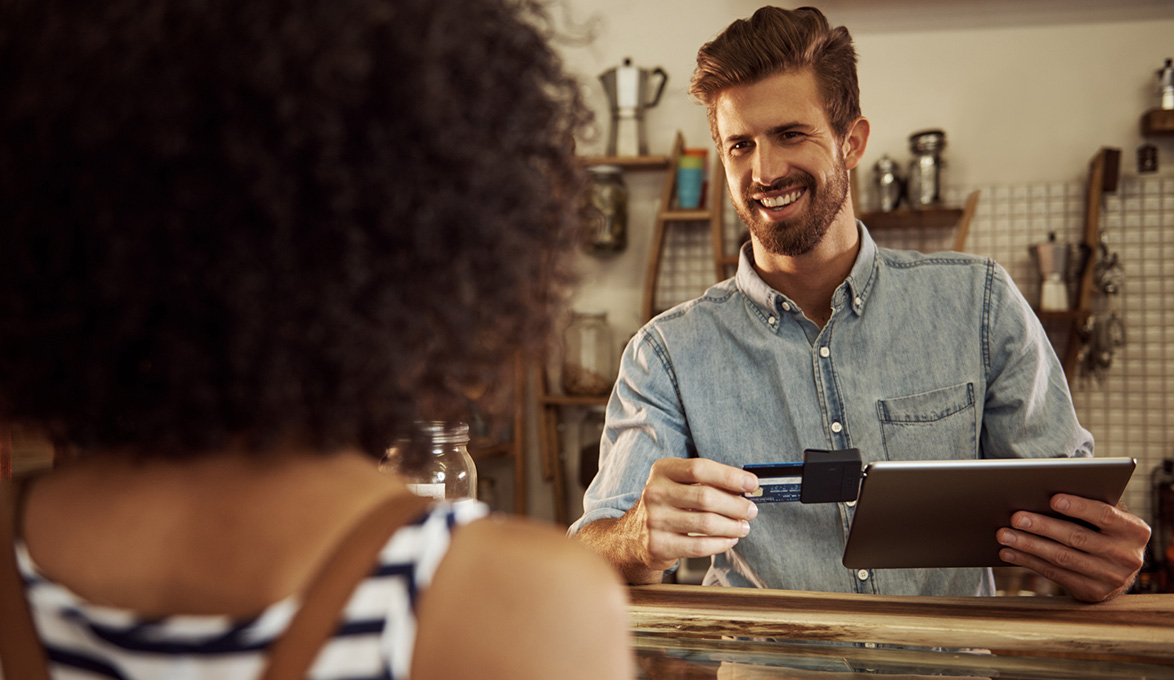 small business owner using mobile tablet POS systems to accept card payment