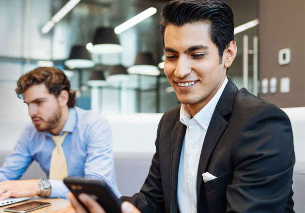 A businessman checks his phone for confirmation of an instant payment