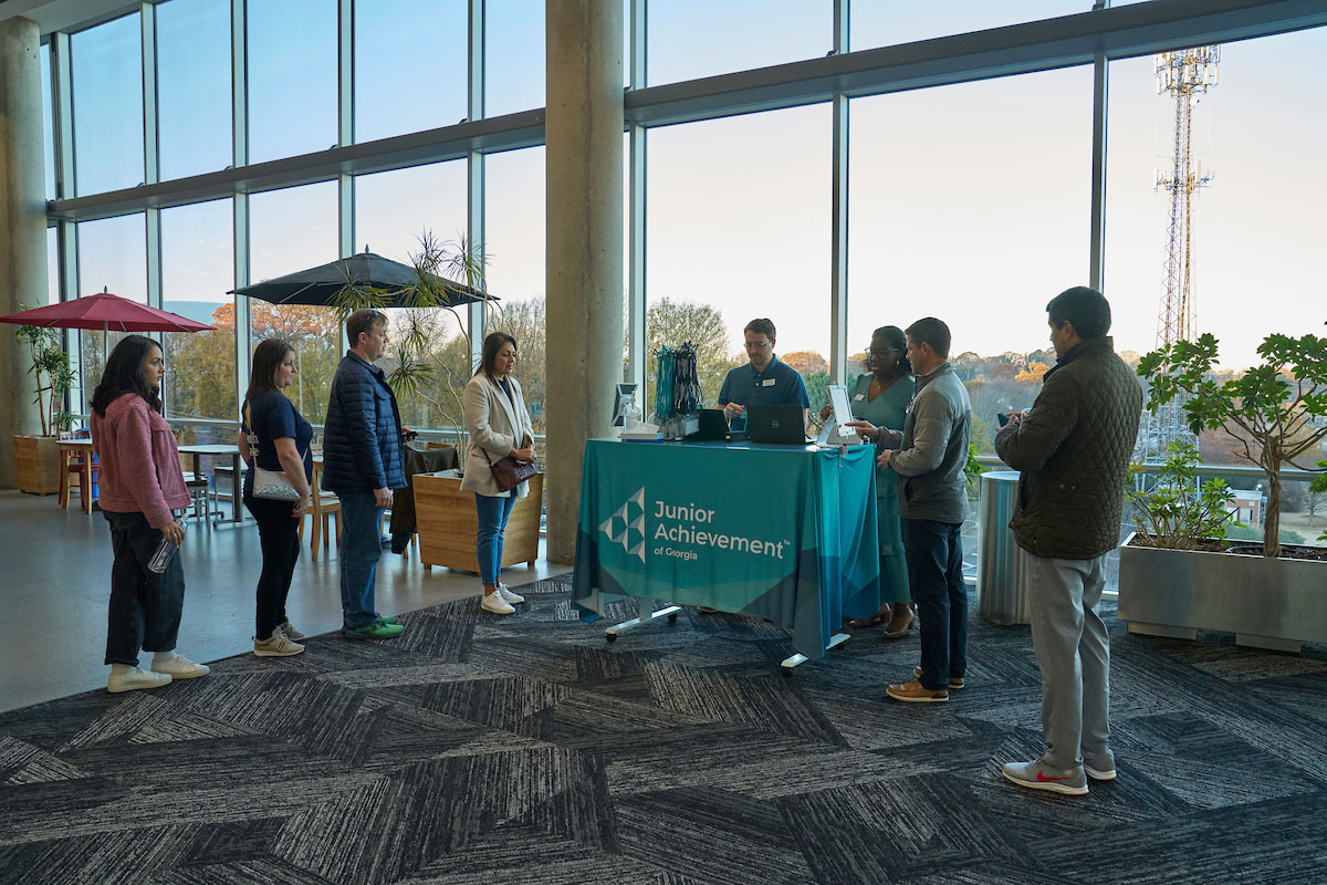 People gathering by the Junior Achievement table