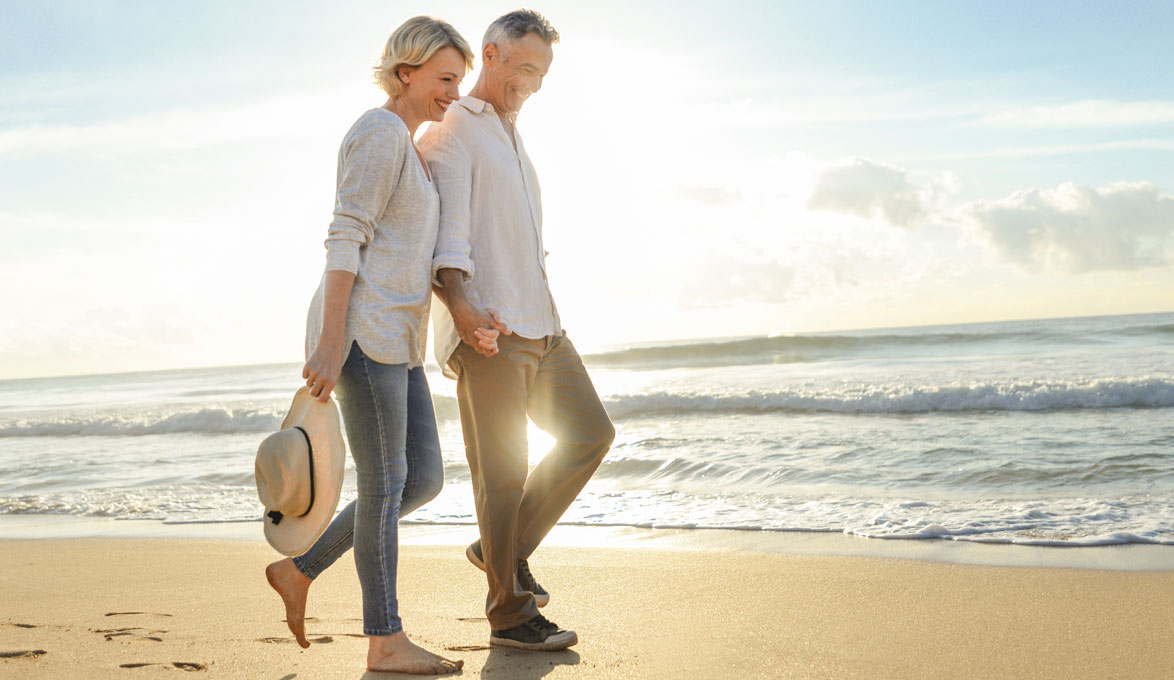 couple holding hands walking on the beach
